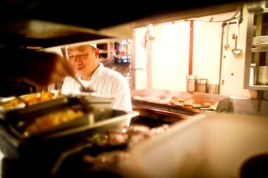 Kokk som arbeider i et travelt restaurantkjøkken